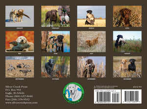 Calendar with monthly images of dogs and birds on a brown background, featuring Silver Creek Press branding.