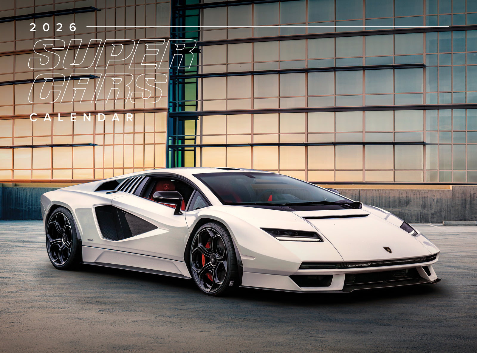 White sports car in front of a modern building with '2026 Super Cars Calendar' text.