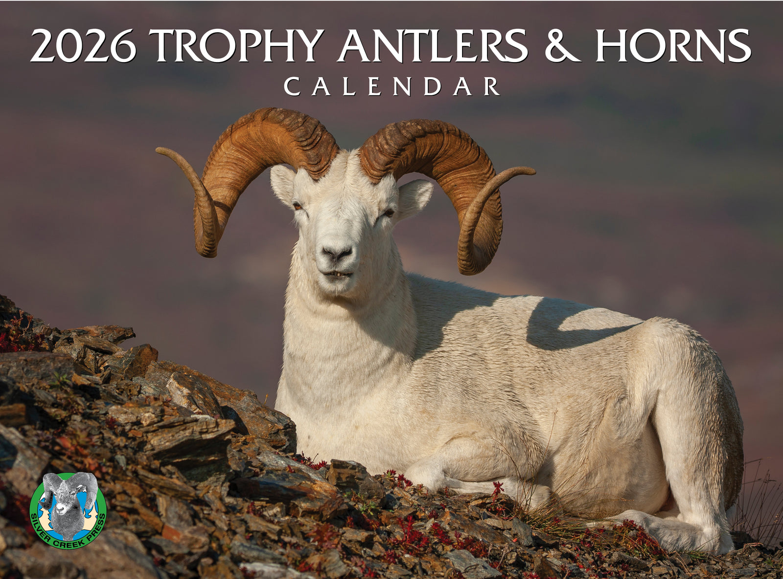 Calendar cover featuring a ram with large antlers and horns on a rocky landscape.